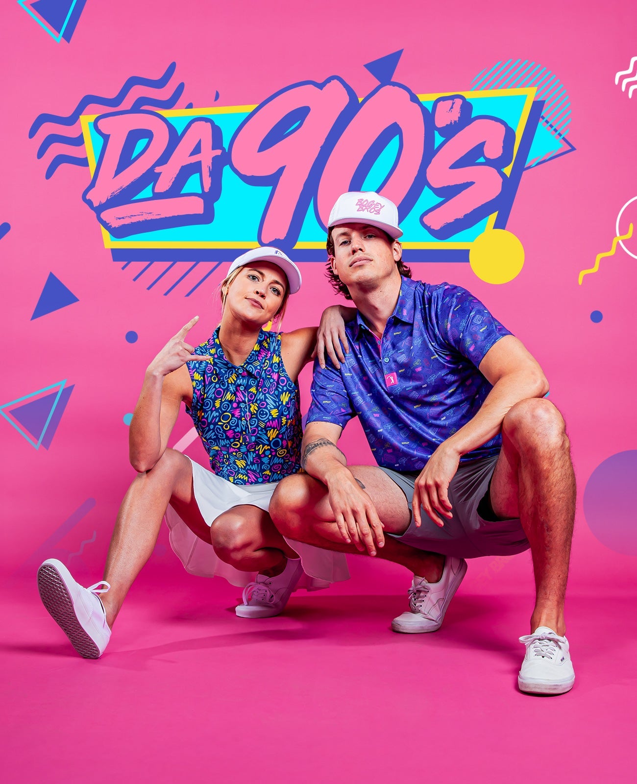 Two young adults in colorful 90s-inspired outfits and caps pose in front of a bright pink backdrop with “DA 90’S” in bold graffiti-style text and playful geometric shapes.