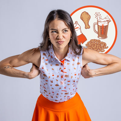 A woman wears the Wingin' It - White - Women's Polo, standing playfully with bent arms and a funny face. Behind her is a circular graphic showing a chicken drumstick, beer mug, curly fries, and a Hooters uniform.