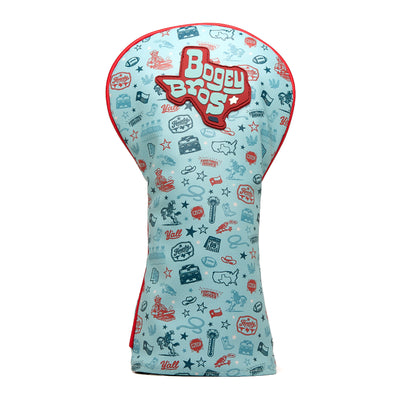 Introducing the Everything’s Bigger - Driver Headcover: a light blue cover edged with bold red trim and adorned with Bogey Bros lettering in crisp white and vibrant red. Made from high-quality PU leather, this driver headcover boasts a lively, all-over pattern of embroidered golf-themed doodles—including clubs, balls, trophies, maps, and the word “Yall”—all rendered in red and blue for a fun and playful design.