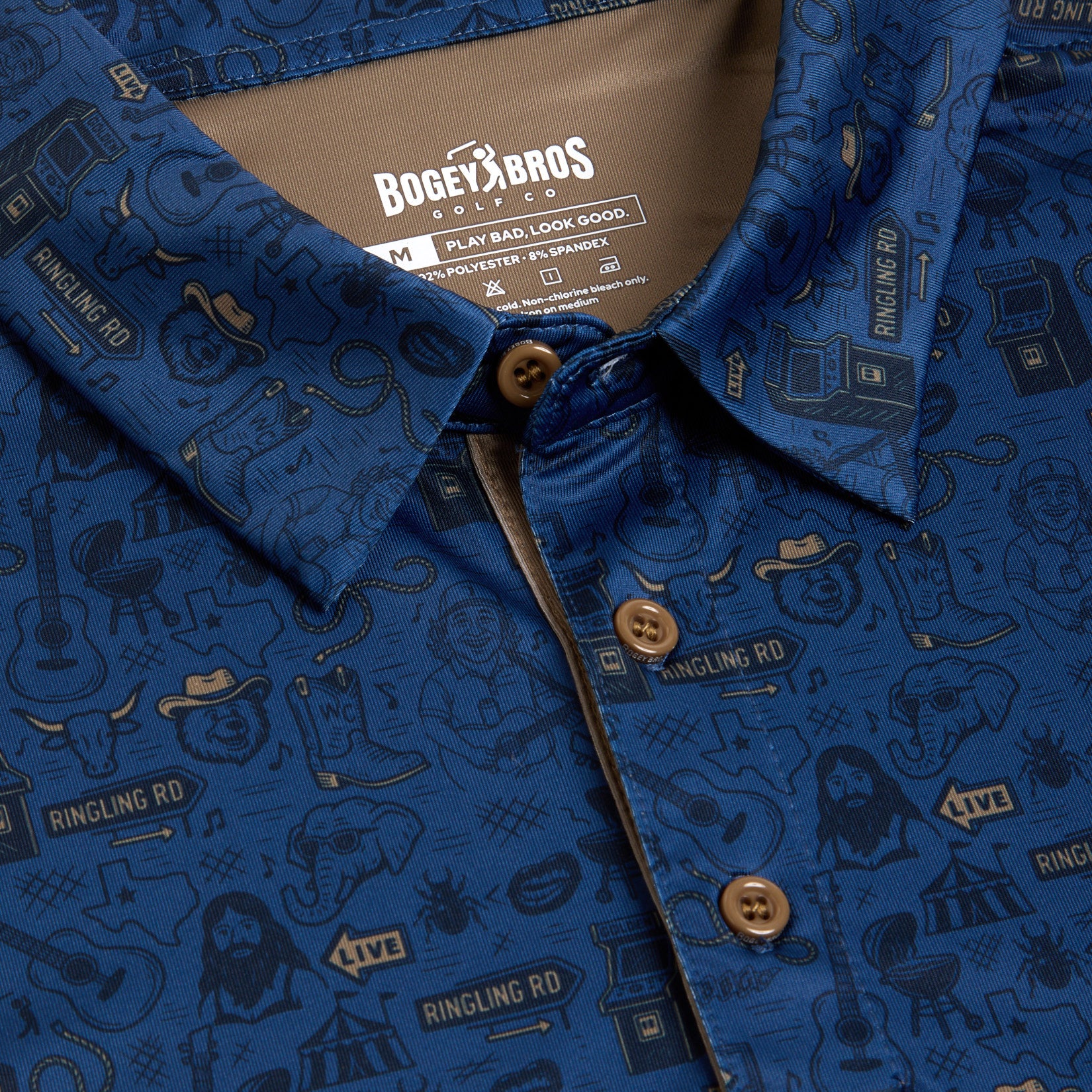 A blue Ringling Road - Polo by Bogey Bros, size medium, featuring brown buttons and a pattern of guitars, microphones, cowboy boots, hats, and the text “RINGLING RD.” Made from polyester and spandex.