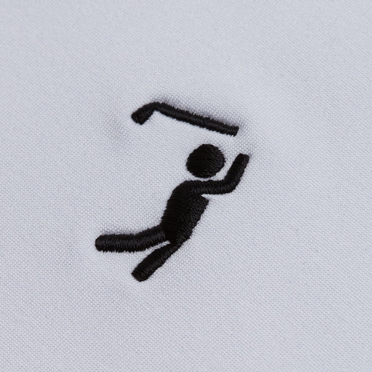 A black embroidered stick figure appears on white fabric, depicted in motion with one arm raised and holding a bent object resembling a hockey stick above its head. The minimalistic design, featuring thick lines to convey activity and playfulness, perfectly complements the White - Hoodie’s athletic fit for both comfort and style.