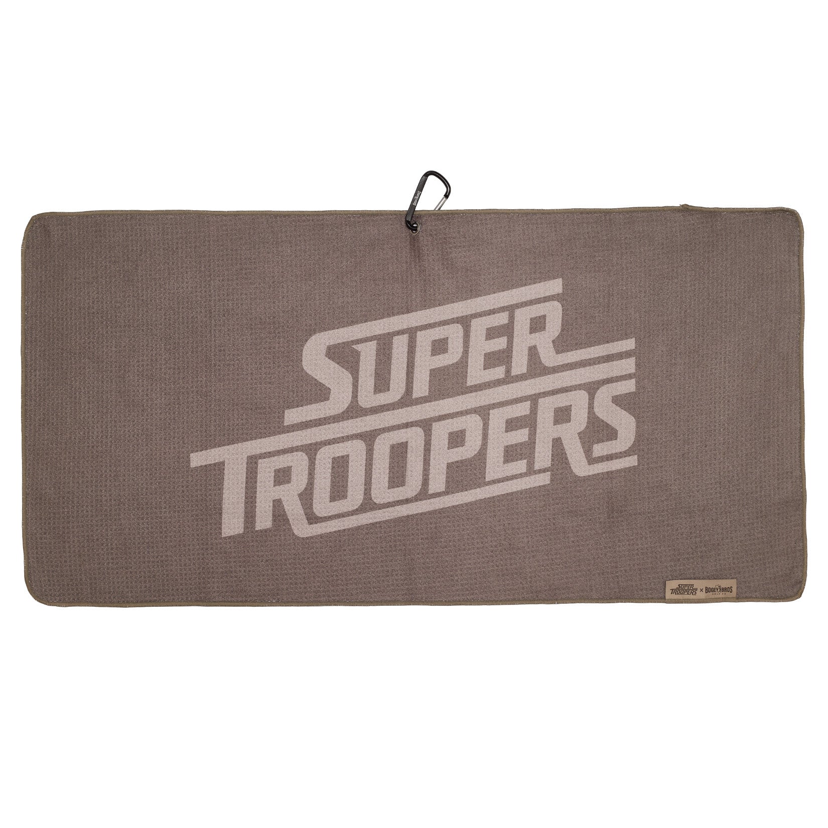 Rectangular brown towel with large, light-colored text reading Super Troopers diagonally across the center. A black carabiner clip is attached at the top edge, and a small beige label is sewn into the bottom right corner.
