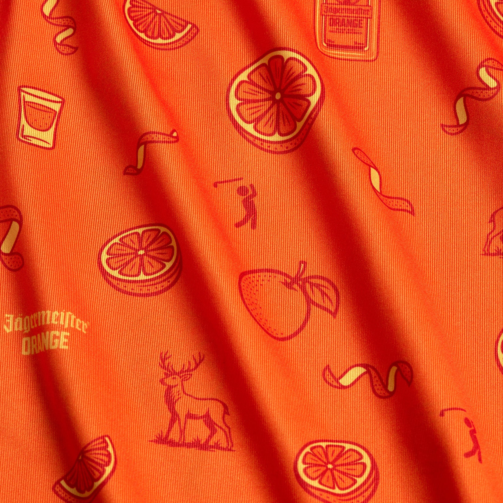 The Main Squeeze - Polo features orange fabric with red illustrations of oranges, slices, peaches, deer, shot glasses, a Jägermeister Orange bottle, cocktail twists, and a small golfer in a playful repeat pattern—plus an athletic fit for comfort and style.