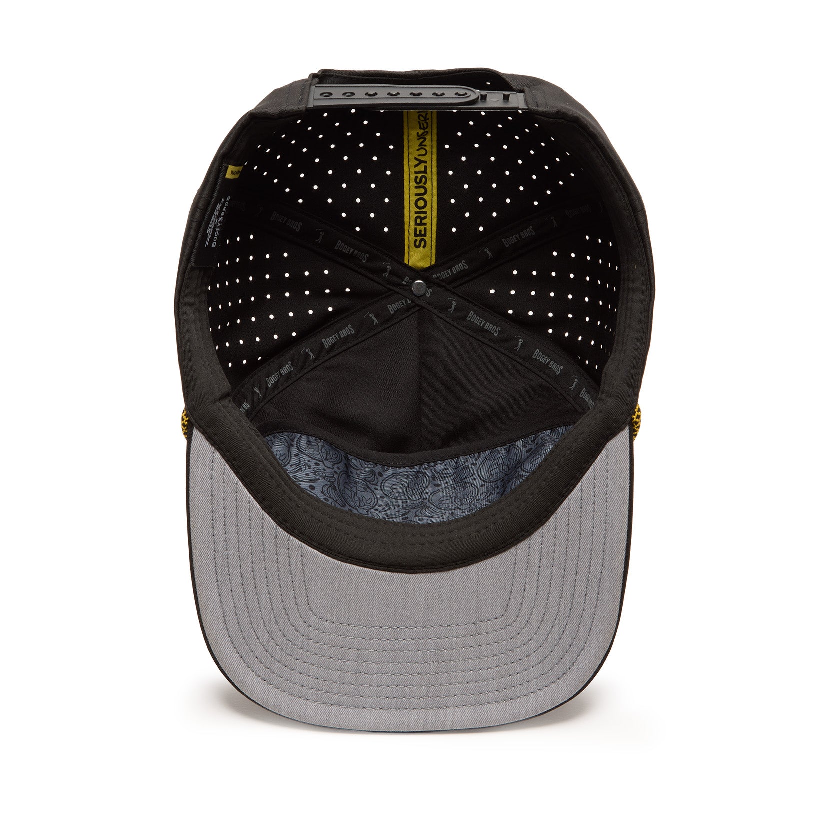 Top-down view of the inside of a black baseball cap with a light gray brim. The lining features SERIOUSLY UNSERIOUS text and a yellow tag. The caps interior has small white dots and a patterned fabric under the brim.