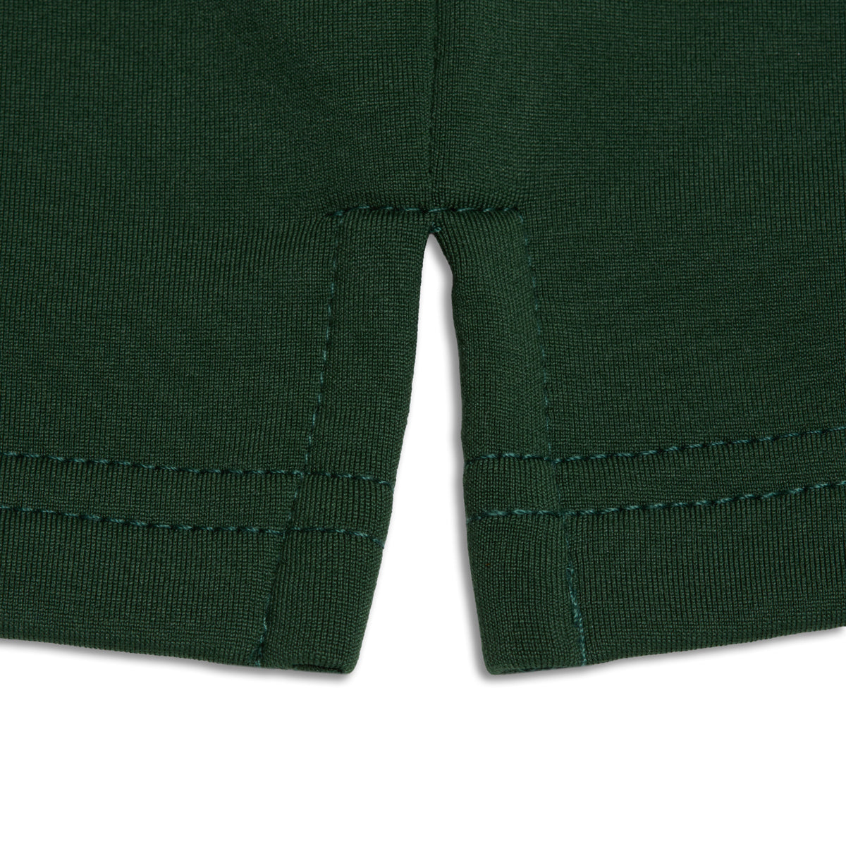Close-up of the bottom hem of the Forest Green - Hoodie. The dark green fabric features two sections separated by a stitched seam, with visible double rows of stitching and a slight curve where the stretchy material meets. The background is white.