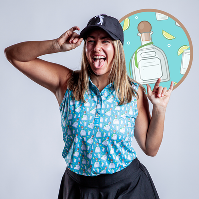 A woman wearing the Tequila - Women's Polo, featuring an athletic fit and tequila bottle pattern, poses playfully with her black cap. Behind her is a blue circular graphic showing a tequila bottle, lemon wedges, and glasses.