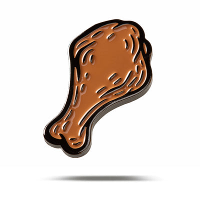 A cartoon-style illustration of a shiny, brown chicken drumstick with a black outline floats above a white background—its look inspired by iron nickel plating. Featured on the Wingin' It - Ball Marker.