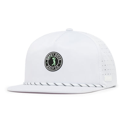 The Bogeyman Stamp White Unstructured Flat Bill Hat is a snapback with performance material, a circular black-and-white Bogey Bros Golf Co. logo on the front, perforated side holes, and a black-and-white patterned rope above the brim.