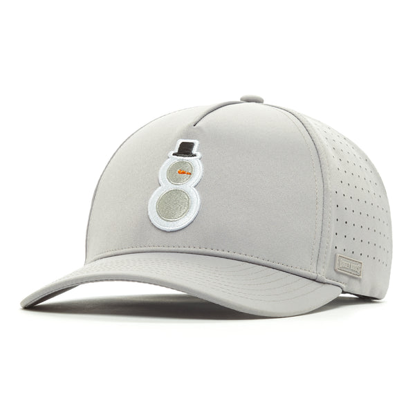 The Snowman Performance Golf Hat is a light gray snapback with a curved brim, perforated side panels, and sweat stain resistant fabric. An embroidered snowman decorates the front; a metallic stitched label accents the side.