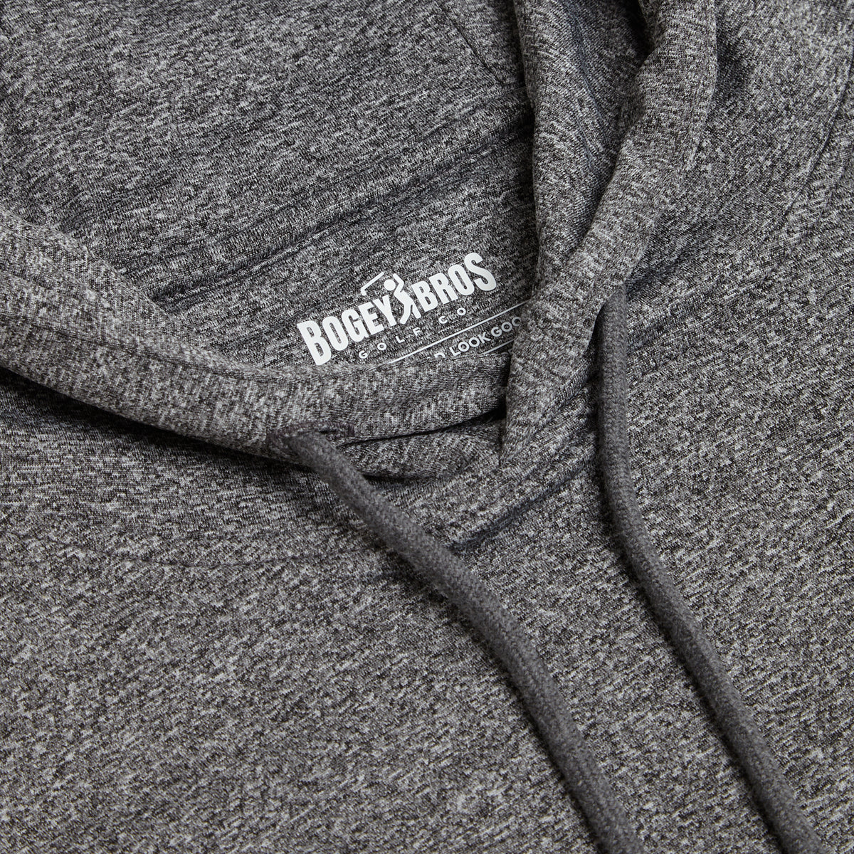 A close-up of the Heather Gray - Hoodie showcases its charcoal grey marled fabric and neck label. The white logo displays BOGEY BROS GOLF CO with a golfer icon, and beneath it is the phrase LOOK GOOD. Designed with an athletic fit, this hoodie is finished with two matching charcoal gray drawstrings hanging from the hood.