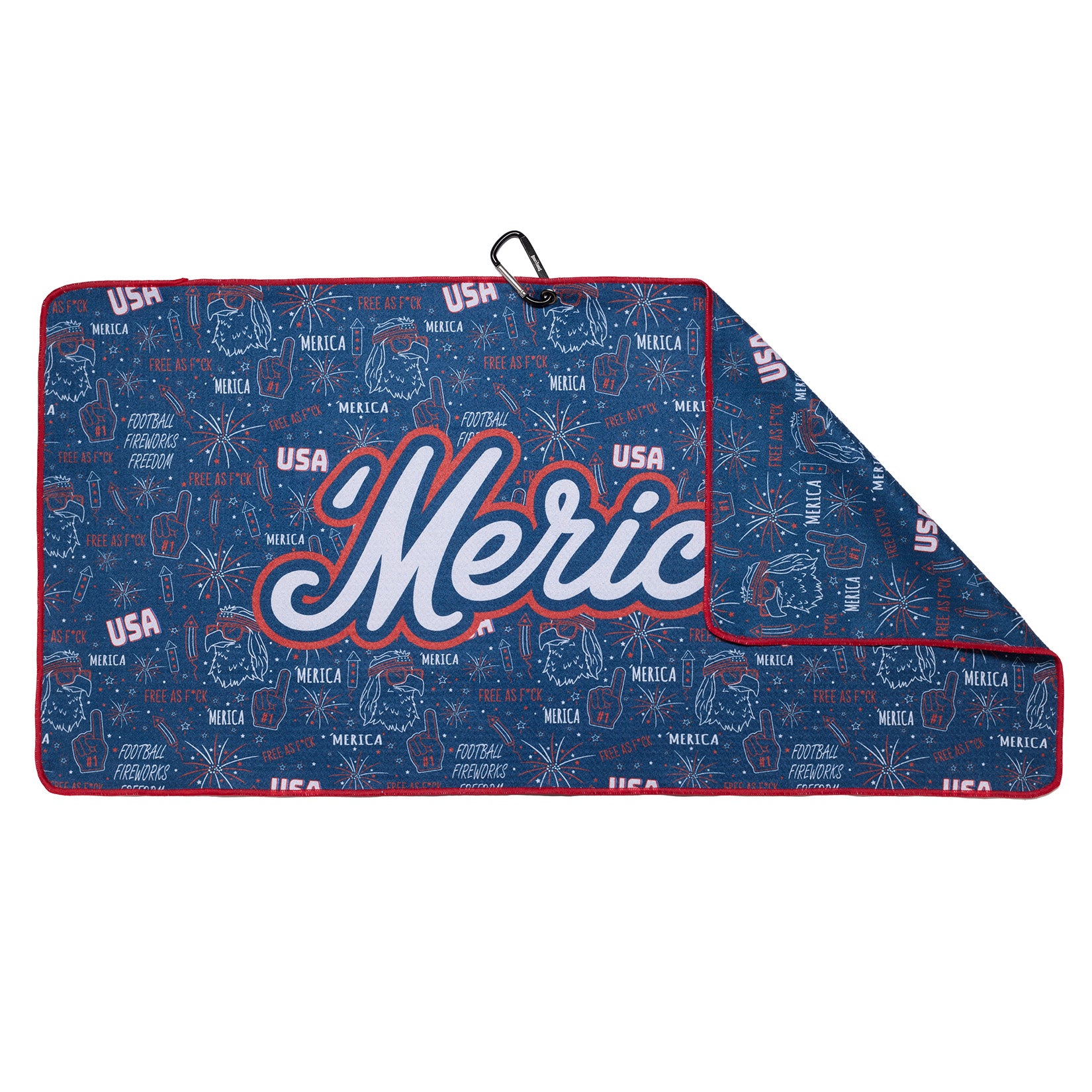 A blue picnic blanket with red trim features “’Merica” in bold, stylized white and red letters, surrounded by USA-themed graphics like fireworks, eagles, stars, and phrases such as “USA” and “FREEDOM.” A metal clip is attached in the upper left corner.