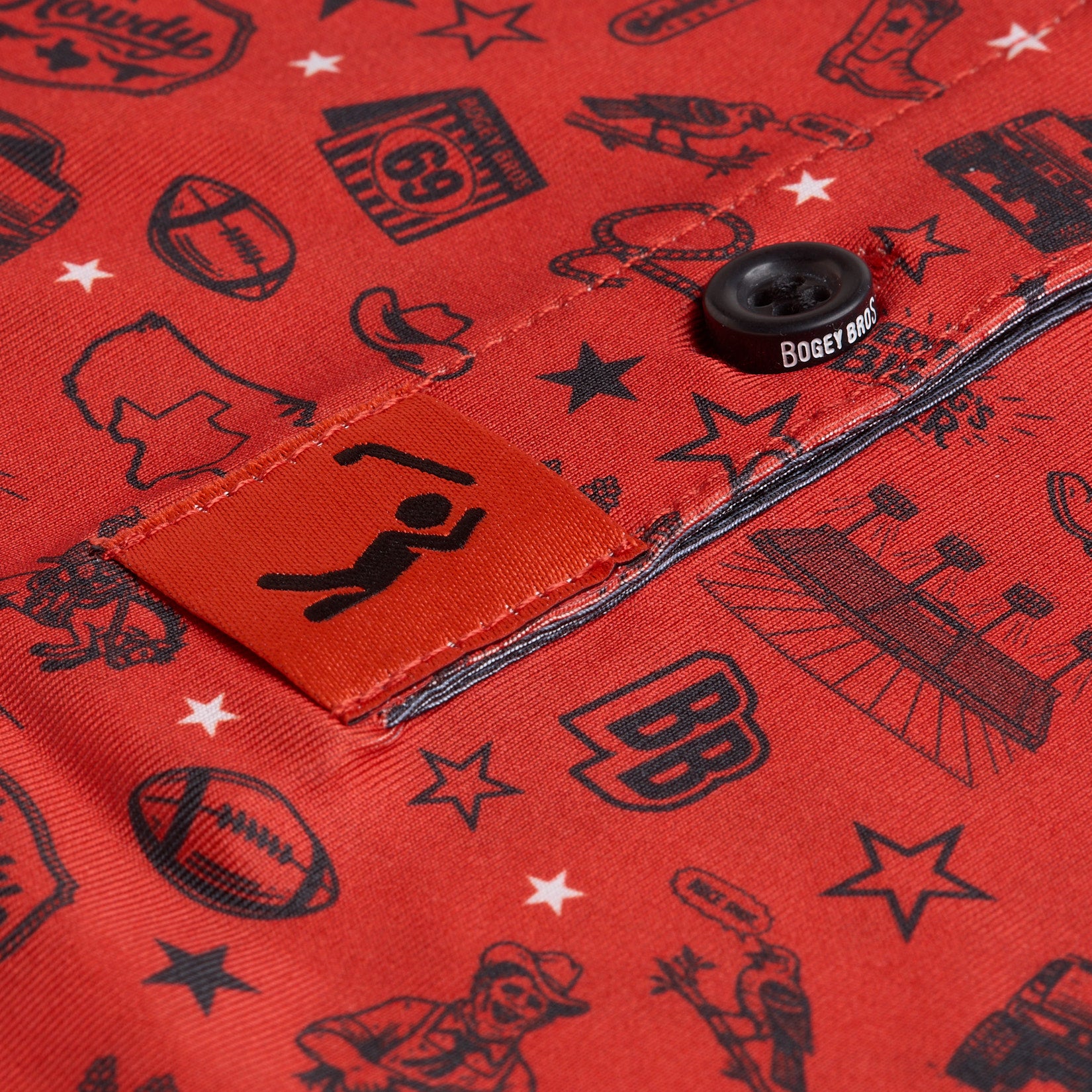Close-up of a red shirt pocket with black illustrated sports and Western motifs, a black button reading Bogey Bros, and a stylized figure logo on an orange tag. The shirt features images like footballs, stars, and a cowboy hat.