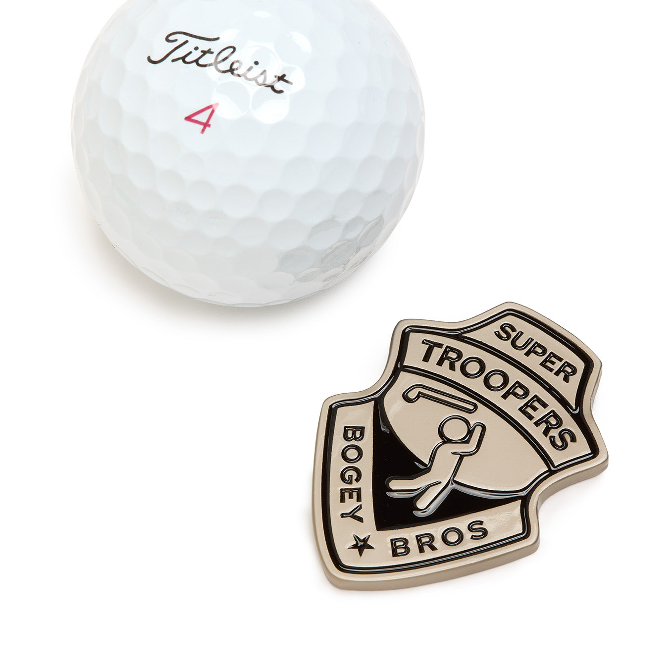 A white Titleist golf ball marked with a red number 4 sits beside The Badge - Ball Marker, a metallic iron-nickel plated, badge-shaped marker that reads SUPER TROOPERS BOGEY BROS and displays an outline of a golfer swinging a club at the center; it features a heavy metal construction and comes with a magnetic clip for secure attachment.