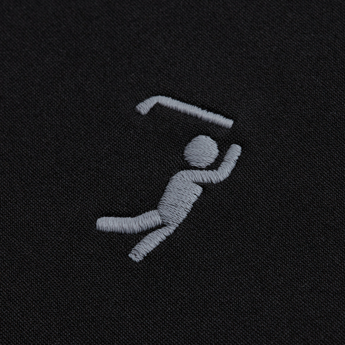 A gray stick figure is embroidered on the Black - Hoodie, appearing to swing forward while gripping a bent bar overhead in a minimalist design—using simple lines and shapes to suggest dynamic gymnastics or athletic movement.