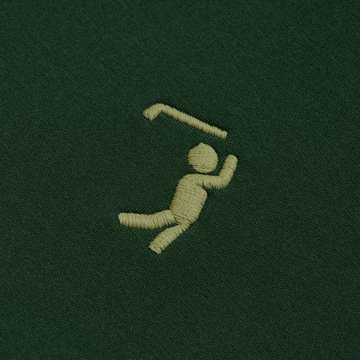 A small, yellow embroidered figure mid-swing with a golf club stands out against the dark green fabric of the Forest Green - Hoodie. The stylized design captures dynamic motion, with arms raised and one leg bent—making this hoodie an ideal match for your favorite moisture-wicking athletic shorts on the course.