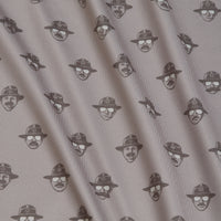 Patterned fabric with small, repeating black line drawings of faces wearing hats and sunglasses on a light background. The fabric has soft folds and diagonal shadows, giving it a textured look. Each face is spaced evenly in rows.