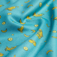 Close-up of the Banana Split Cheeks - Polo's blue fabric, featuring a playful banana pattern. The smooth, slightly shiny material is moisture-wicking for cool comfort, while its gently wrinkled look adds unique charm.