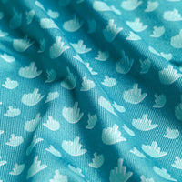 Close-up of Bogey Bros Birdie Finger - Polo's turquoise fabric with a pattern of small white flying birds. The soft, slightly shiny material features gentle folds and offers UPF 50 sun protection. Birds are evenly spaced across the surface.