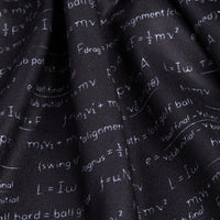 A close-up of the Easy Game - Polo shows its black fabric with white mathematical formulas and symbols. The athletic-fit cloth is slightly wrinkled, distorting some text, but equations, variables, and operators stay visible.