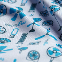 Close-up of Exclusively Fans - Polo’s white fabric, printed with blue and black electric fan illustrations in standing, ceiling, and handheld styles. Features BogeBros branding and moisture-wicking for comfort in warm conditions.