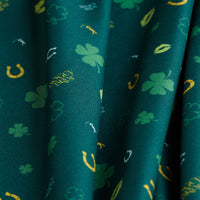 Gettin' Lucky - Polo features green fabric with UPF 50 protection and a festive St. Patrick’s Day pattern of yellow and green shamrocks, horseshoes, and small leaves, combining sun shielding with holiday style.