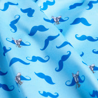Close-up of the Mustache Ride - Polo’s light blue fabric, featuring playful dark blue mustaches and cartoon flies. The polo offers UPF 50 protection, with a slightly wrinkled texture adding dimension to its whimsical design.