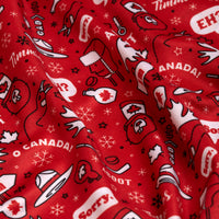 A close-up of the O Canada - Polo's red fabric, featuring playful Canadian-themed illustrations like maple leaves, beavers, moose, hats, mittens, and fun phrases. The polo has an athletic fit and appears slightly wrinkled.