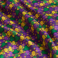 Close-up of the Phat Tuesday - Polo's vibrant yellow, green, and purple Mardi Gras-inspired fabric with abstract scalloped motifs and cross-like symbols on softly wrinkled, moisture-wicking material.
