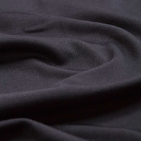 Close-up of Solid Charcoal - Polo fabric in dark gray, featuring smooth folds and subtle texture. Light softly highlights its fine weave and moisture-wicking properties, emphasizing depth, movement, and comfort for athletic fit styles.