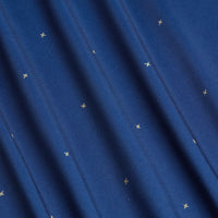 Close-up of Exes - Navy - Polo: soft, blue moisture-wicking fabric with small, evenly spaced gold stars and gentle vertical folds that create subtle shadows and a wavy look.
