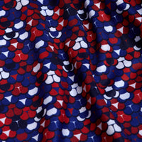 A close-up of the Whale Tail - Freedom Cheeks - Polo fabric shows a vibrant geometric pattern with red, white, and blue semi-circles. The slightly wrinkled texture adds depth while offering UPF 50 protection for safe outdoor wear.