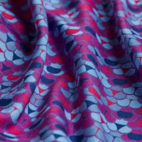 A close-up of the Whale Tail - Polo's moisture-wicking fabric, showcasing a dynamic wavy texture and a vibrant abstract pattern with overlapping pink, blue, and dark purple shapes for a lively look.