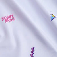 The Chillax - Women's Polo features white fabric with playful pink BOGEY BROS text and colorful geometric shapes. Its moisture-wicking material, gentle folds, and visible texture offer comfort and style for active wear.