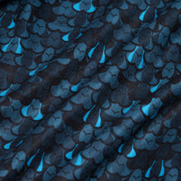 Close-up of the Eyes Up Here - Zapped Women's Polo fabric featuring a blue and teal scalloped pattern on a dark background. The soft, textured material is moisture wicking, with subtle folds and ripples enhancing its depth.