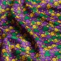 The Phat Tuesday Women's Polo features a colorful pattern in purple, yellow, and green with stylized floral and geometric designs. Made with moisture-wicking fabric to keep you comfortable, this polo offers both vibrant style and performance.