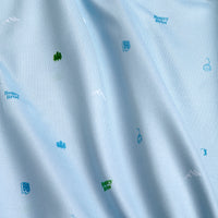 Close-up of Pine - Women's Polo in light blue, featuring small green trees, ski lifts, BB initials, Bogey Bros text, and mountain outlines in a playful pattern on smooth, moisture-wicking fabric for extra comfort.