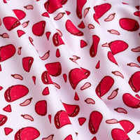 A close-up of the Pink Taco - Women's Polo shows white fabric with vibrant pink and red taco and chili pepper prints. The athletic-fit polo features moisture-wicking material, with cartoon-style food designs adding playful flair.