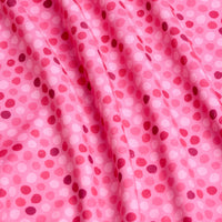 A close-up of the Dots - Pink - Women's Polo shows pink, moisture-wicking fabric with a wavy texture and small, scattered pink dots. The soft, slightly glossy material has gentle folds that create subtle shadows and highlights.