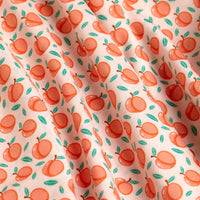 Close-up of the Tooty Frooty - Women's Polo, featuring super stretchy fabric with a repeating orange peach and green leaf pattern on a cream background. Slight wrinkles create gentle shadows and waves in the design.