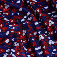 A close-up of the Whale Tail - Freedom Cheeks Women's Polo shows slightly wrinkled fabric with a red, white, and blue abstract pattern on a dark background. The material offers moisture-wicking comfort and added texture.