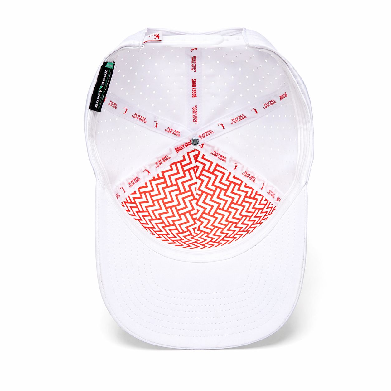An upside-down Bogeyman White/Red Performance Golf Hat (Snapback) shows its interior with red and white zigzag crown patterns, red seam print, plain white brim with ventilation holes, and a black-and-green tag on the inner band.
