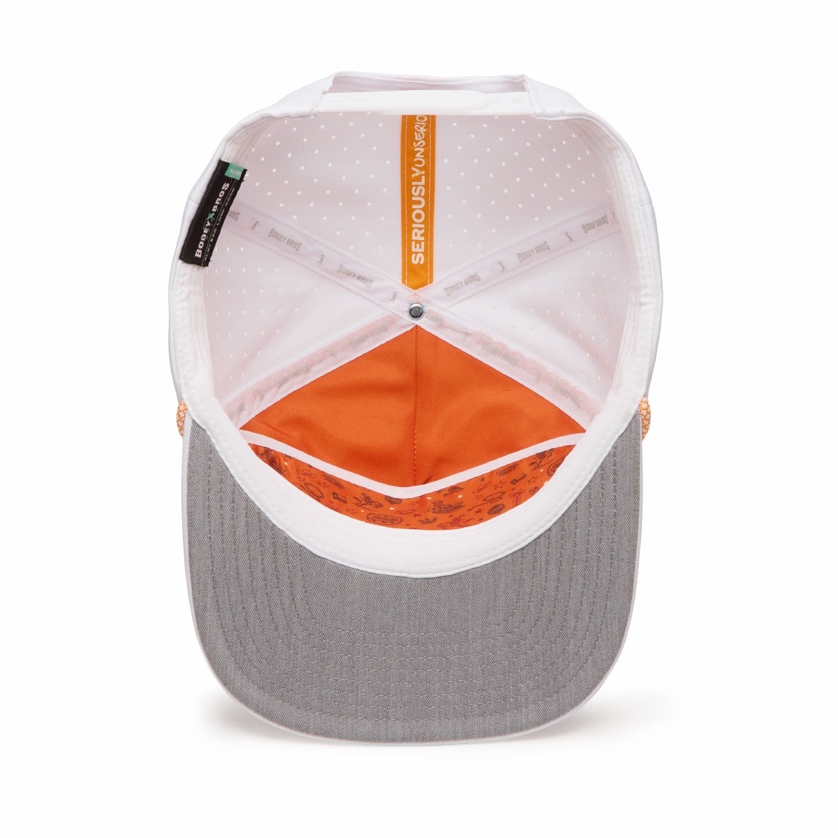 A top-down view of the inside of a baseball cap with a grey brim, white crown, orange inner lining, white polka-dot pattern, and a visible “SERIOUSLY SNACKS” label at the top. The sweatband has repeating branding and small designs near the brim.