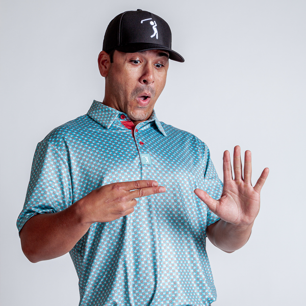 A man in an athletic Finger Bang - Polo—teal, patterned, moisture-wicking—and black hat looks surprised, holding up a hand with fingers spread as if counting to five. He stands against a plain light gray background.