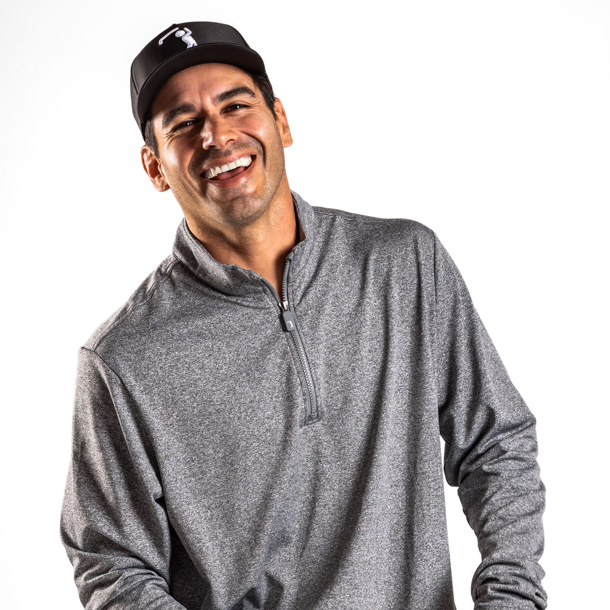 A smiling man with dark hair is wearing the Heather Gray - Q-Zip, a heather-gray quarter-zip pullover with an athletic fit, along with a black baseball cap featuring a white golf logo. Against a solid white background, he laughs energetically, his head tilted slightly to his right.