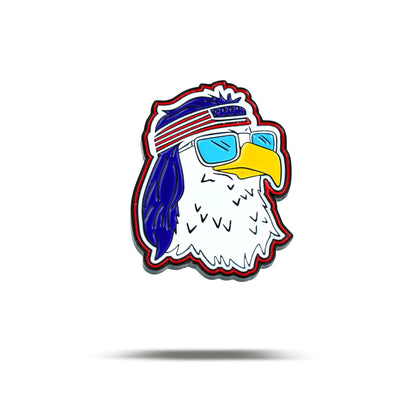 The FREEagle - Ball Marker features a cartoon eagle head with white feathers, yellow beak, blue sunglasses, and a red, white, and blue headband. Outlined in black with a red stroke on a white background, it projects a cool and confident vibe.