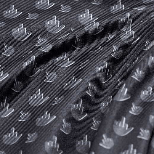 Close-up of black textured fabric featuring a repeating woven pattern of small, white, stylized hand shapes. Fabric is softly gathered, creating gentle folds and shadows that emphasize the shine and texture of the material.