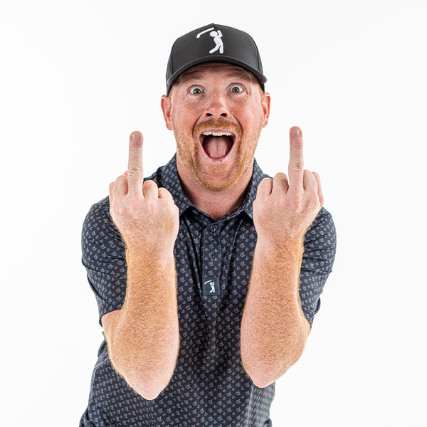 A man with a reddish beard and black cap wears the Birdie Finger - Raven - Polo, an athletic fit, moisture-wicking shirt with a pattern. He faces the camera on a white background, smiling widely and raising both middle fingers.