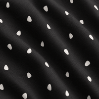 A close-up of the Dingleberry Doodles - Polo reveals dark, fine-woven fabric with a subtle, rippled texture. The material showcases a repeating pattern of small, off-white teardrop-shaped spots arranged in diagonal rows against a black background. Engineered for comfort, the polo’s advanced moisture-wicking properties keep you cool and dry while highlighting gentle folds and uniform design elements across its innovative cloth.
