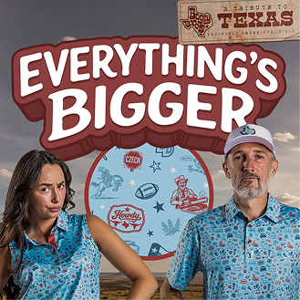 A man and woman wear matching light blue patterned polo shirts featuring Texas-themed icons. Above them, bold text reads EVERYTHINGS BIGGER in front of a circular pattern of the shirts design. A wooden sign at the top right corner reads A TRIBUTE TO TEXAS. The background is a desert sunset.