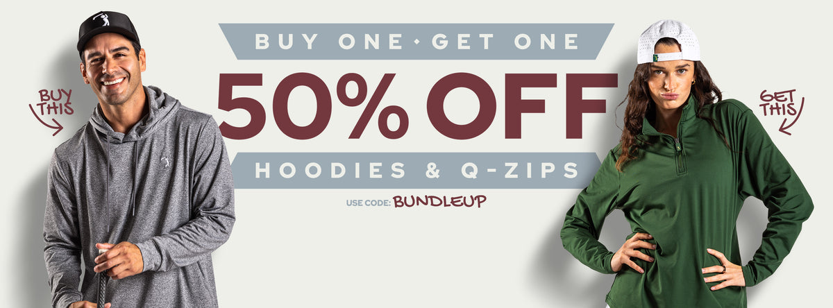 A smiling man in a gray hoodie and a serious woman in a green hoodie and white cap, both standing by bold text: Buy One Get One 50% Off Hoodies & Q-Zips. Arrows point to their clothing with Buy This and Get This. Promo code: BUNDLEUP.